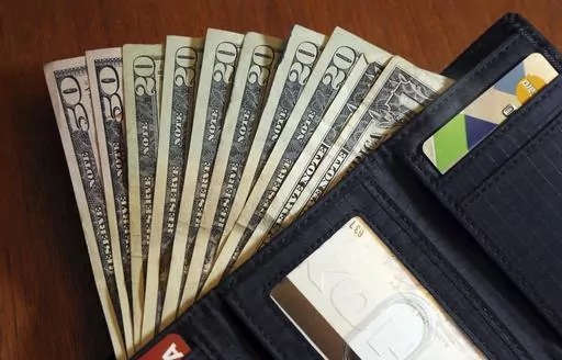 Cash is fanned out from a wallet in North Andover, Mass., June 15, 2018. Parenting comes with many responsibilities, and one is raising financially independent kids. Generally, it’s best to leave the money in your retirement accounts safely tucked away. Withdrawing money early can trigger taxes and a 10% penalty, plus it can cut into what you otherwise would’ve had for retirement. (AP Photo/Elise Amendola, File)