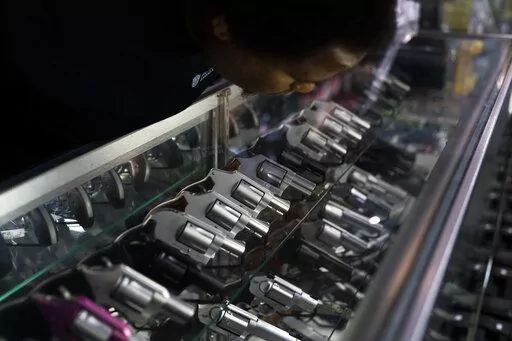 Sales associate Elsworth Andrews arranges guns on display at Burbank Ammo & Guns in Burbank, Calif., Thursday, June 23, 2022. The Supreme Court has ruled that Americans have a right to carry firearms in public for self-defense, a major expansion of gun rights. The court struck down a New York gun law in a ruling expected to directly impact half a dozen other populous states. (AP Photo/Jae C. Hong)