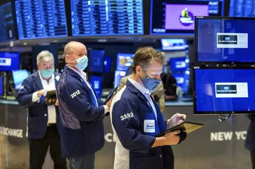 In this photo provided by the New York Stock Exchange, Robert Charmak, right, works with fellow traders on the floor of the New York Stock Exchange, Monday, Jan. 10, 2022. Stocks fell broadly in afternoon trading on Wall Street Monday and bond yields continued rising as investors anticipate moves by the Federal Reserve to raise interest rates. (Courtney Crow/New York Stock Exchange via AP)