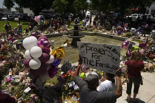 People visit a memorial set up in a town square to honor the victims killed in this week's elementary school shooting in Uvalde, Texas Saturday, May 28, 2022. (AP Photo/Jae C. Hong)