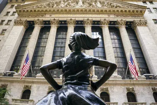FILE- In this Aug. 25, 2020, file photo, the 'Fearless Girl' bronze sculpture, commissioned by State Street Global Advisors, looks towards the New York Stock Exchange from its roadside perch in New York. Amid the push to get U.S. boardrooms to look more like companies’ customers and employees, advocates are finally seeing just how steep the task will be.  Boards of directors at publicly traded U.S. companies are much more white and much less diverse than the overall population, often starkly s
