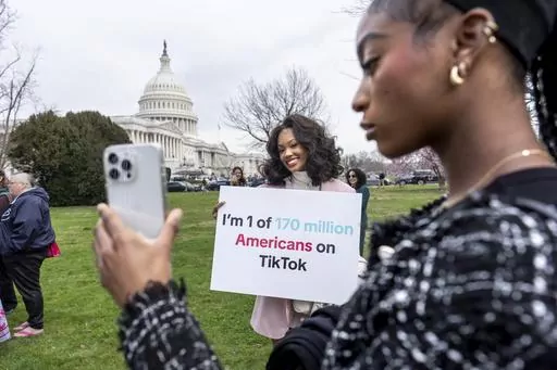 Devotees of TikTok, Mona Swain, center, and her sister, Rachel Swain, right, both of Atlanta, pose with a sign at the Capitol in Washington, March 13, 2024. TikTok's extensive lobbying campaign is the latest tech industry push since the House passed legislation that would ban the popular app if its China-based owner doesn't sell its stake. TikTok has been urging its users to call their representatives. (AP Photo/J. Scott Applewhite, File)
