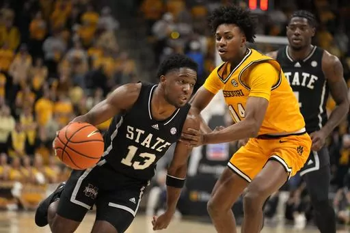 Mississippi State's Josh Hubbard (13) heads to the basket past Missouri's Anthony Robinson II (14) during the first half of an NCAA college basketball game Saturday, Feb. 10, 2024, in Columbia, Mo. (AP Photo/Jeff Roberson)