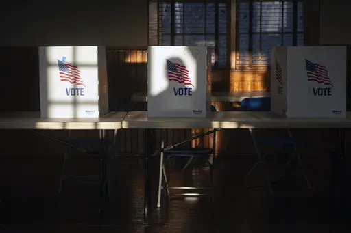 The shadow of a voter entering the precinct at St. Joseph Catholic Church in Gluckstadt, Miss., is cast on a privacy divider for people filling out ballots at Precinct 205 at during the primary election Tuesday, March 12, 2024. (Barbara Gauntt/The Clarion-Ledger via AP)
