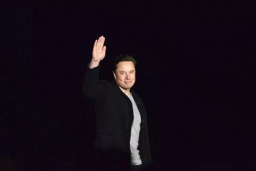 Elon Musk waves while providing an update on SpaceX's Starship, Thursday, Feb. 10, 2022, near Brownsville, Texas. In April 2022, a group of Tesla shareholders suing Musk over some 2018 tweets about taking the company private is asking a federal judge to order him to stop commenting on the case. (Miguel Roberts/The Brownsville Herald via AP, File)
