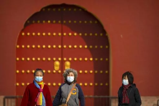 People wearing face masks walk at the Temple of Heaven in Beijing, Saturday, Nov. 12, 2022. Everyone in a district of 1.8 million people in China's southern metropolis of Guangzhou was ordered to stay home Saturday to undergo virus testing and a major city in the southwest closed schools as another rise in infections was reported. (AP Photo/Mark Schiefelbein)