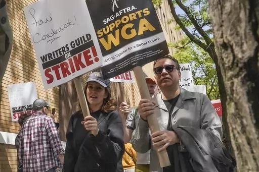 Actors and comedians Tina Fey, center, and Fred Armisen, right, join striking members of the Writers Guild of America on the picket line during a rally outside Silvercup Studios, Tuesday May 9, 2023, in New York. Unionized Hollywood actors on the verge of a strike have agreed to allow a last-minute intervention from federal mediators but say they doubt a deal will be reached by a negotiation deadline late Wednesday, July 12, 2023. (AP Photo/Bebeto Matthews, File)