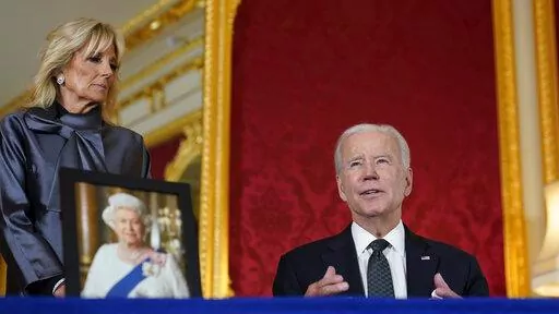President Joe Biden signs a book of condolence at Lancaster House in London, following the death of Queen Elizabeth II, Sunday, Sept. 18, 2022, as first lady Jill Biden looks on. (AP Photo/Susan Walsh)