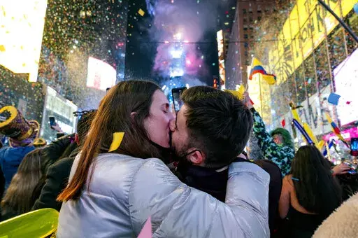 Irene Mayoral, left and Gerald Nuell of Spain kiss as they celebrate in Times Square in New York Saturday, Jan. 1, 2022, as they attend New Year's Eve celebrations. The couple became engaged Friday. (AP Photo/Craig Ruttle)