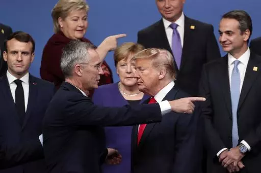 NATO Secretary-General Jens Stoltenberg, front center left, speaks with U.S. President Donald Trump, front center right, after a group photo at a NATO leaders meeting at The Grove hotel and resort in Watford, Hertfordshire, England, Dec. 4, 2019. As Trump becomes the first former president to face federal charges that could put him in jail, many Europeans are watching the case closely. But hardly a single world leader has said a word recently about the man leading the race for the Republican par
