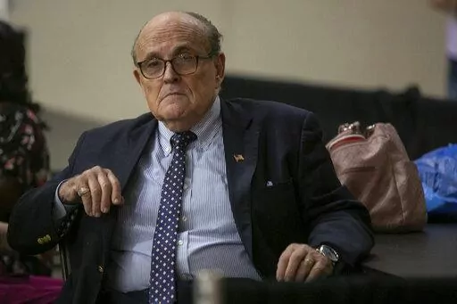 Former New York City Mayor Rudy Giuliani sits where delegate votes will be counted as nominee for statewide positions are introduced during the Michigan Republican convention at Devos Place in Grand Rapids, Mich., on Saturday, April 23, 2022. (Daniel Shular/The Grand Rapids Press via AP)