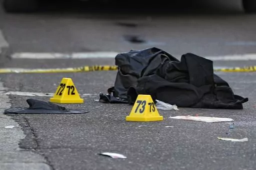A witch hat, left, and an unidentified object are shown in the street near evidence markers in the Ybor City section of Tampa, Fla., after a shooting, Oct. 29, 2023. Shootings across the U.S. over the party weekend before Halloween have left at least 11 people dead and more than 70 injured. Authorities say the deaths between Friday and Sunday included two in Tampa, Florida, three in Texarkana, Texas, and two each in Kansas, San Antonio, Texas and Mansfield, Ohio. Many involved altercations arisi