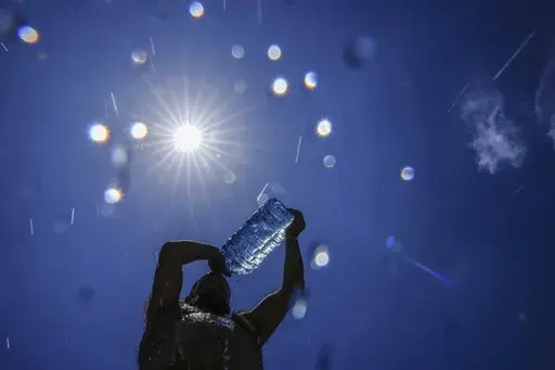 A man pours cold water onto his head to cool off on a sweltering hot day in the Mediterranean Sea in Beirut, Lebanon, July 16, 2023. As temperatures and humidity soar outside, what's happening inside the human body can become a life-or-death battle decided by just a few degrees. (AP Photo/Hassan Ammar, File)