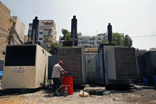 Mamdouh al-Amari refuels privately-owned diesel generators that provide power to homes and businesses, in the southern suburbs of Beirut, Lebanon, July 16, 2018. Internet services were disrupted in Lebanon Sunday, Jan. 16, 2022, because of diesel shortages, according to the state provider, adding another essential service to the list of casualties of the country’s snowballing economic crisis. (AP Photo/Bilal Hussein, File)