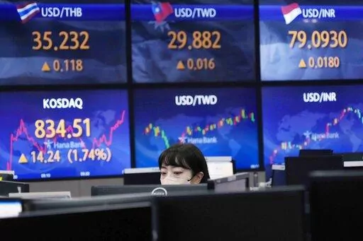 A currency trader watches monitors at the foreign exchange dealing room of the KEB Hana Bank headquarters in Seoul, South Korea, Thursday, Aug. 11, 2022. Shares advanced Thursday in Asia after benchmarks closed at three-month highs on Wall Street as investors cheered a report showing inflation cooled more than expected in July. (AP Photo/Ahn Young-joon)