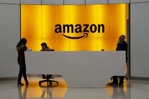 In this Feb. 14, 2019, file photo people stand in the lobby for Amazon offices in New York. Amazon is kicking off its annual security-focused cloud computing conference on Tuesday amid a slowdown in its profitable cloud business Amazon Web Services, or AWS. (AP Photo/Mark Lennihan, File)