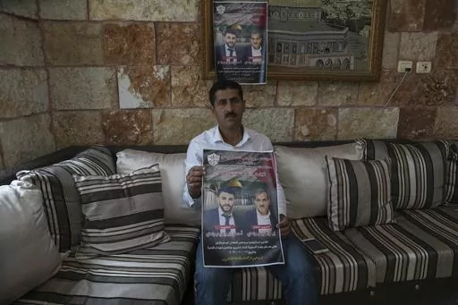 Abdelazim Wadi, 50, holds up a poster commemorating his brother, Ibrahim Wadi, and his nephew, Ahmed Wadi, who were killed by Israeli settlers during a funeral procession on Oct. 12 in the rural Palestinian village of Qusra, West Bank, Sunday, Nov. 12, 2023. With the world’s attention focused on the fighting in Gaza, Israeli settler violence against Palestinians since Oct. 7 has surged to the highest levels ever recorded by the United Nations. Palestinians say this Israel-Hamas war has left th