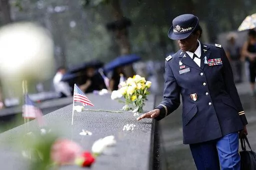A retired colonel from the U. S. Army Nurse Corps walks beside the reflecting pool at the commemoration ceremony on the 21st anniversary of the September 11, 2001 terror attacks on Sunday, Sept. 11, 2022 in New York. (AP Photo/Stefan Jeremiah)