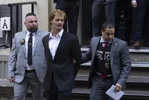 Daniel Penny, center, is walked by New York Police Department detectives out of the 5th Precinct, May 12, 2023, in New York. Penny, the man charged with manslaughter for putting an agitated New York City subway rider in a fatal chokehold, has been indicted by a grand jury, an expected procedural step that will allow the criminal case to continue. (AP Photo/Jeenah Moon, File)