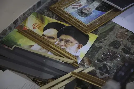 Broken pictures of Iranian spiritual leaders Ayatollah Ali Khamenei and Ayatollah Ruhollah Khomeini lie on the floor at the Iranian embassy after opposition forces took control of the city in Damascus, Syria, Sunday, Dec. 8, 2024. (AP Photo/Ghaith Alsayed)