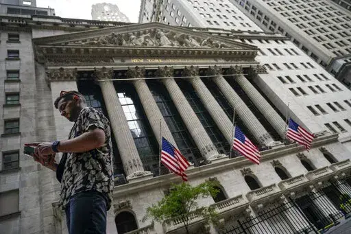 Pedestrians walk past the New York Stock Exchange, on July 8, 2022, in New York.  Stocks are opening lower on Wall Street Wednesday, Aug. 17,  as traders absorb some discouraging news about how much Americans are spending. (AP Photo/John Minchillo, file)