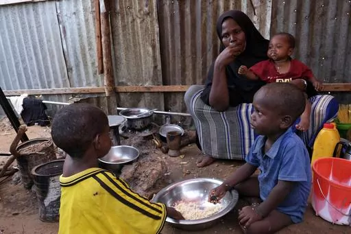 Hadiiq Abdulle Mohamed eats with her children as she speaks during an interview with The Associated Press at an internally displaced people camp on the outskirts of Mogadishu, Somalia, March 24, 2023. Children experienced the highest number of grave violations in conflicts ever verified by the United Nations in 2022, with the conflicts between Israeli and Palestinians and in Congo and Somalia putting the most in peril, the U.N. children's agency said Wednesday. (AP Photo/Farah Abdi Warsameh, Fil