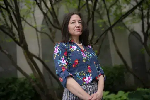 Allyson Jacobs stands for a portrait outside her workplace, Wednesday, May 4, 2022, in New York. For Jacobs, life in her 20s and 30s was about focusing on her career in health care and enjoying the club scene in New York City. It wasn't until she turned 40 that she and her husband started trying to have children. They had a son when she was 42.   (AP Photo/John Minchillo)