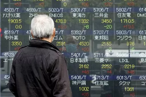 A person looks at an electronic stock board showing Japan's Nikkei 225 index at a securities firm, March 3, 2023, in Tokyo. Asian stock markets were mixed Thursday after the Federal Reserve said its economists expect a “mild recession” this year. (AP Photo/Eugene Hoshiko, File)