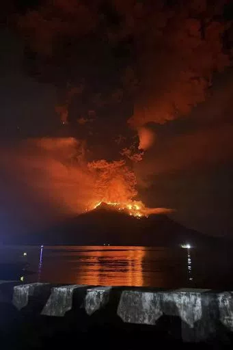 In this photo released by Sitaro Regional Disaster Management Agency (BPBD Sitaro), hot molten lava glows at the crater of Mount Ruang as it erupts in Sanguine Islands, Indonesia, Wednesday, April 17, 2024. Indonesian authorities issued a tsunami alert Wednesday after eruptions at Ruang mountain sent ash thousands of feet high. Officials ordered more than 11,000 people to leave the area. (BPBD Sitaro via AP)