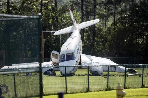 A small plane sits in a field behind the Ocean Springs Middle School in Ocean Springs, Miss., Friday, June 23, 2023, after crashing upon takeoff from the Ocean Springs Airport. (Hannah Ruhoff/The Sun Herald via AP)