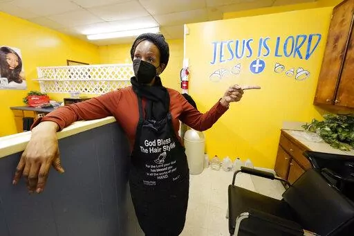 Belinda Smith, owner of Styles of Essence, a hair salon in south Jackson, Miss., speaks of the need to have gallons of water available to use for rinsing clients hair because of the uncertainty of the city's water service, Wednesday, Jan. 26, 2022. The city's ongoing water woes sometimes requires the area water to be shut off without warning. (AP Photo/Rogelio V. Solis)