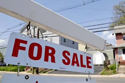 A "for sale" sign hangs from a post outside of a vacant business building in Belleville, N.J., Thursday, May 3, 2018.  The Federal Reserve on Wednesday, July 27,  raised its benchmark interest rate by a hefty three-quarters of a point for a second straight time in its most aggressive drive in three decades to tame high inflation.  By raising borrowing rates, the Fed makes it costlier to take out a mortgage or an auto or business loan.(AP Photo/Julio Cortez, File)