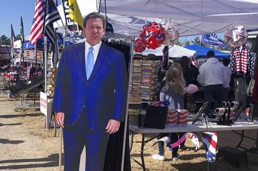 A cardboard cutout of Florida Gov. Ron DeSantis stands in the merchandise area outside former President Donald Trump's rally in Conroe, Texas, Saturday, Jan. 29, 2022. At Trump’s rally, there were signs of change. Next to the Trump hats, shirts and flags sat a collection of Ron “DeSantis 2024” bumper stickers. The vast majority of those interviewed at Trump’s rally enthusiastically cheered the prospect of another Trump run. But there were some who conceded that, perhaps, there might be a