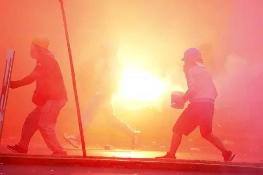 A so-called "deactivator" and "front-line" activist, face off with police during an anti-government protest in Lima, Peru, Saturday, Jan. 28, 2023. Protesters are seeking immediate elections, President Dina Boluarte's resignation, the release of ousted President Pedro Castillo and justice for protesters killed in clashes with police. (AP Photo/Martin Mejia)