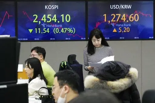 A currency trader passes by the screens showing the Korea Composite Stock Price Index (KOSPI), left, and the foreign exchange rate between U.S. dollar and South Korean won at the foreign exchange dealing room of the KEB Hana Bank headquarters in Seoul, South Korea, Wednesday, Feb. 15, 2023. Asian stock markets fell Wednesday after U.S. inflation edged down less than expected, fueling concern the Federal Reserve might think more interest rate hikes are needed. (AP Photo/Ahn Young-joon)