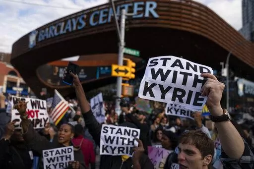 Protesters rallying against COVID-19 vaccination mandates and in support of basketball player Kyrie Irving gather in the street outside the Barclays Center before an NBA basketball game between the Brooklyn Nets and the Charlotte Hornets, Sunday, Oct. 24, 2021, in New York. From the NBA's Kyrie Irving missing the first months of the Brooklyn Nets' season before making a partial return, to the NFL's Aaron Rodgers going from revered veteran to polarizing figure, to a diplomatic standoff over tenni