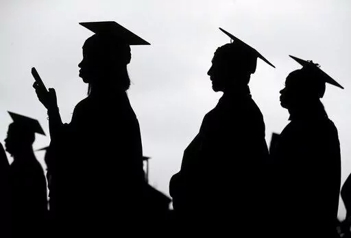 New graduates line up before the start of a community college commencement in East Rutherford, N.J., on May 17, 2018. President Joe Biden is expected to announce Wednesday Aug. 24, 2022 that many Americans can have up to $10,000 in federal student loan debt forgiven. (AP Photo/Seth Wenig, File)