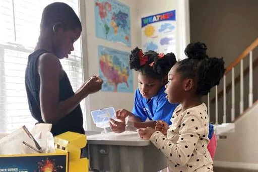 In this undated photo provided by Dalaine Bradley, Ahmad Waller, 11, Zion Waller, 10, and Drew Waller, 7, left to right, study during homeschooling, in Raleigh, N.C. (Courtesy of Dalaine Bradley via AP)