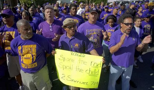 Supporters of St. Augustine High School including Byron Bernard, class of 1980, center, with "Spare the Rod, Spoil the Child" poster, demand the right of self-governance including a corporal punishment policy, march and cheer in front of the Archdiocese of New Orleans at Notre Dame Seminary Saturday March 26, 2011. A school district in southwest Missouri has decided to bring back spanking as a form of discipline for students, but only if their parents agree. Missouri and Louisiana are among 19 s
