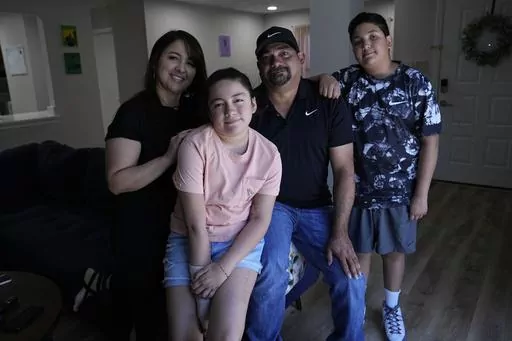 Mayah Zamora, second from left, a survivor of the mass shooting at Robb Elementary in Uvalde, Texas, poses for a photo with her mom Christina, left, dad Ruben, and brother Zach, right, at their home in San Antonio, Tuesday, June 27, 2023. Besides medical bills and the weight of trauma and grief, mass shooting survivors and their family members contend with scores of other changes that show how thoroughly their lives have been upended by violence. (AP Photo/Eric Gay)