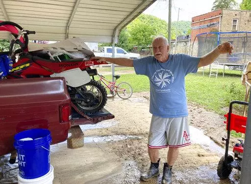 Paul Francis describes how flood waters damaged his property in Garrett, Ky., Saturday, July 30, 2022. Francis was born in the home 73 years ago but his wife wants to leave the area because of the flooding. The tiny town of Garrett was completely under water when floodwaters struck eastern Kentucky last week. (AP Photo/Dylan Lovan)