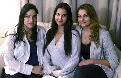 FILE — Three of Amer Fakhoury's four daughters, from left, Guila, Macy, and Zoya Fakhoury, gather Nov. 5, 2019, in Salem, N.H. Amer Fakhoury was a Lebanese American restaurant owner who made his first trip back to Lebanon in 2019 in nearly 20 years to see family. In Lebanon he was accused of torturing and killing inmates at a former prison where his family says he had worked as a clerk. Fakhoury was released in March 2020 and died that August from lymphoma. The Fakhourys are trying to sue Leba
