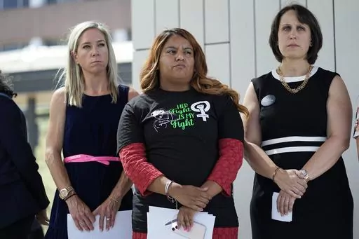 Amanda Zurawski, who developed sepsis and nearly died after being refused an abortion when her water broke at 18 weeks, left, and Samantha Casiano, who was forced to carry a nonviable pregnancy to term and give birth to a baby who died four hours after birth, center, stand with their attorney Molly Duane outside the Travis County Courthouse, Wednesday, July 19, 2023, in Austin, Texas. A Texas judge ruled Friday, Aug. 4, 2023, the state’s abortion ban has proven too restrictive for women with s