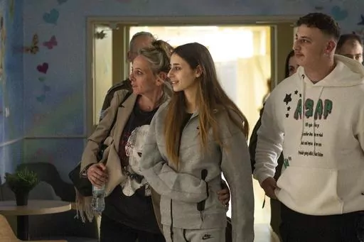 This photo provided by GPO on Friday, Dec. 1, 2023, shows Israeli released hostage Mia Schem, foreground centre, reuniting with her family at Sheba Medical Center in Tel Hashomer, Ramat Gan, Israel. Schem who recently returned from captivity in Gaza said in an interview broadcast Friday Dec. 29, 2023 on Israel’s Channel 13 TV, she was groped by her Palestinian kidnapper and lived in constant fear for weeks. Schem, a dual citizen of Israel and France, had been attending a music festival in sout