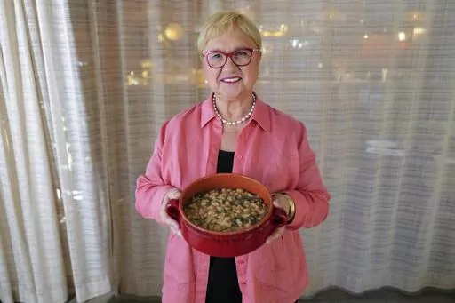 This image released by PBS shows celebrity chef Lidia Bastianich holding her recipe for escarole and white bean soup in Washington, DC on Nov. 7, 2022. The Emmy-award winning TV host, author and restaurateur explores the immigrant experience through food in the PBS special "Lidia Celebrates America: Flavors That Define Us.” (Meredith Nierman/PBS via AP)