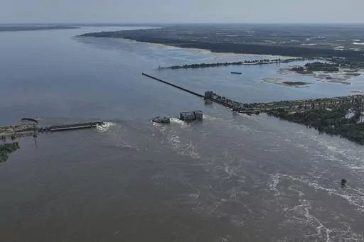 Water flows over the collapsed Kakhovka Dam in Nova Kakhovka, in Russian-occupied Ukraine, Wednesday, June 7, 2023. Russia had the means, motive and opportunity to bring down a Ukrainian dam that collapsed earlier this month while under Russian control, according to exclusive drone photos and information obtained by The Associated Press. (AP Photo, File)