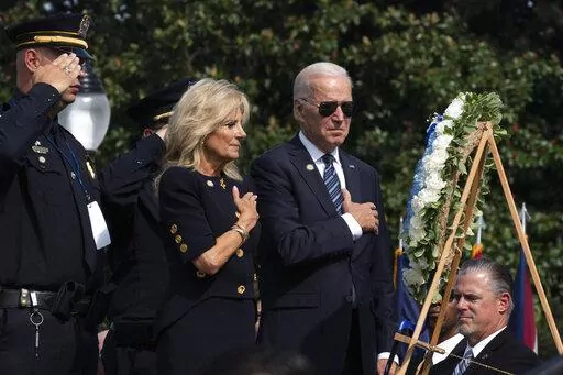 President Joe Biden and first lady Jill Biden put their right hand over their heart after placing flowers on a wreath during a ceremony honoring fallen law enforcement officers at the 40th annual National Peace Officers' Memorial Service at the U.S. Capitol in Washington, Oct. 16, 2021. Saluting on the left is James Smallwood, National Treasurer of the National Fraternal Order of Police. (AP Photo/Manuel Balce Ceneta, File)