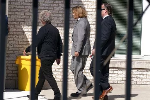 Actor Johnny Depp, center left, leaves the Fairfax County courthouse after a jury selection day in Fairfax Va. Monday, April 11, 2022.  The trial of Depp and Amber Heard, who were married from 2015 to 2017, began with jury selection. ( AP Photo/Jose Luis Magana)