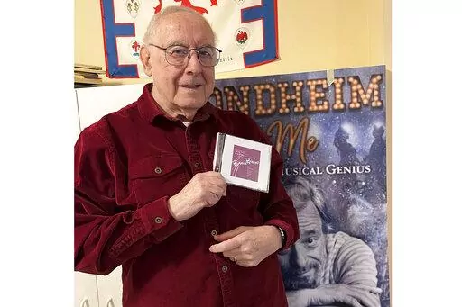 Author and journalist Paul Salsini holds a copy of Stephen Sondheim's first original cast recording of “Phinney's Rainbow” in Milwaukee on Dec. 1, 2022. The CD, which was lost, is a recording of the legendary composer's first student-led musical while he attended Williams College in 1948. (S. Barbara Goertz via AP)