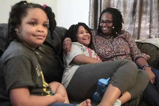 Deleah Payne, 12, center, spends time with her mother Delisa, right, and 6-year-old sister Delynn, left, as they watch movie clips on their living room television in Evansville, Ind., Tuesday evening, Aug. 27, 2019. Deleah and Delynn were both diagnosed with autism. For the first time, autism is being diagnosed more frequently in Black and Hispanic children than in white kids in the U.S., the Centers for Disease Control and Prevention said Thursday, March 23, 2023. (Sam Owens/Evansville Courier 